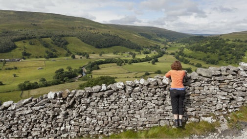 Walker looking at the view at Buckden, Upper Wharfedale, Yorkshire Dales